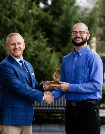 President Young presents a spiritual value award to student Jacob West.