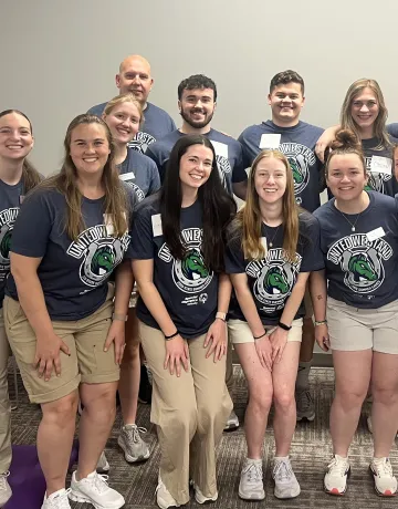 A group of physical therapy students pose together after a fitness event. 