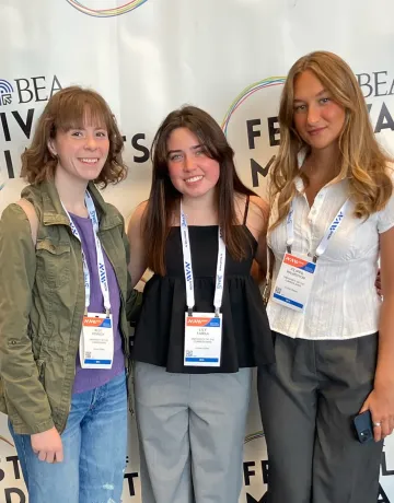 Three college newspaper staff members pose after winning an award. 