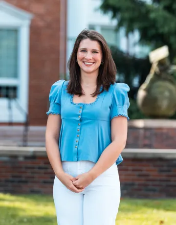 Student Ana Muse poses for a photo in front of the Luecker Building. 
