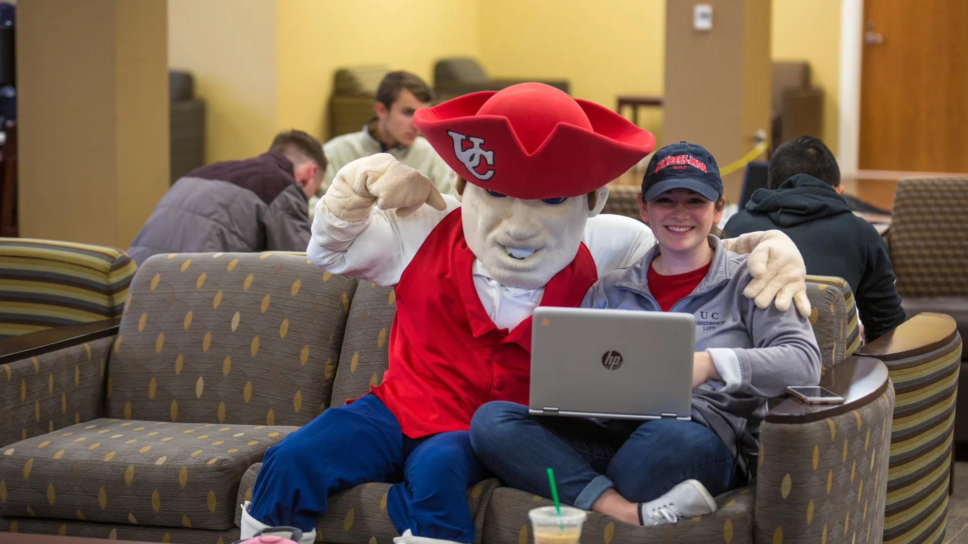 The university mascot posing with a student.