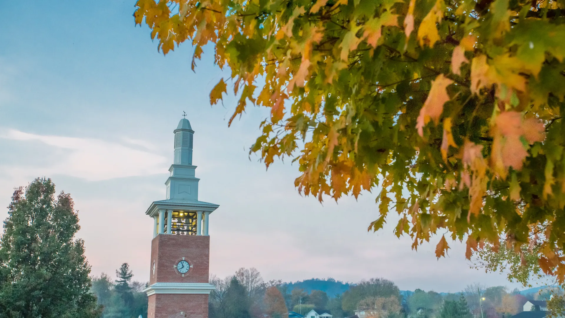 Fall leaves next to tall clock tower