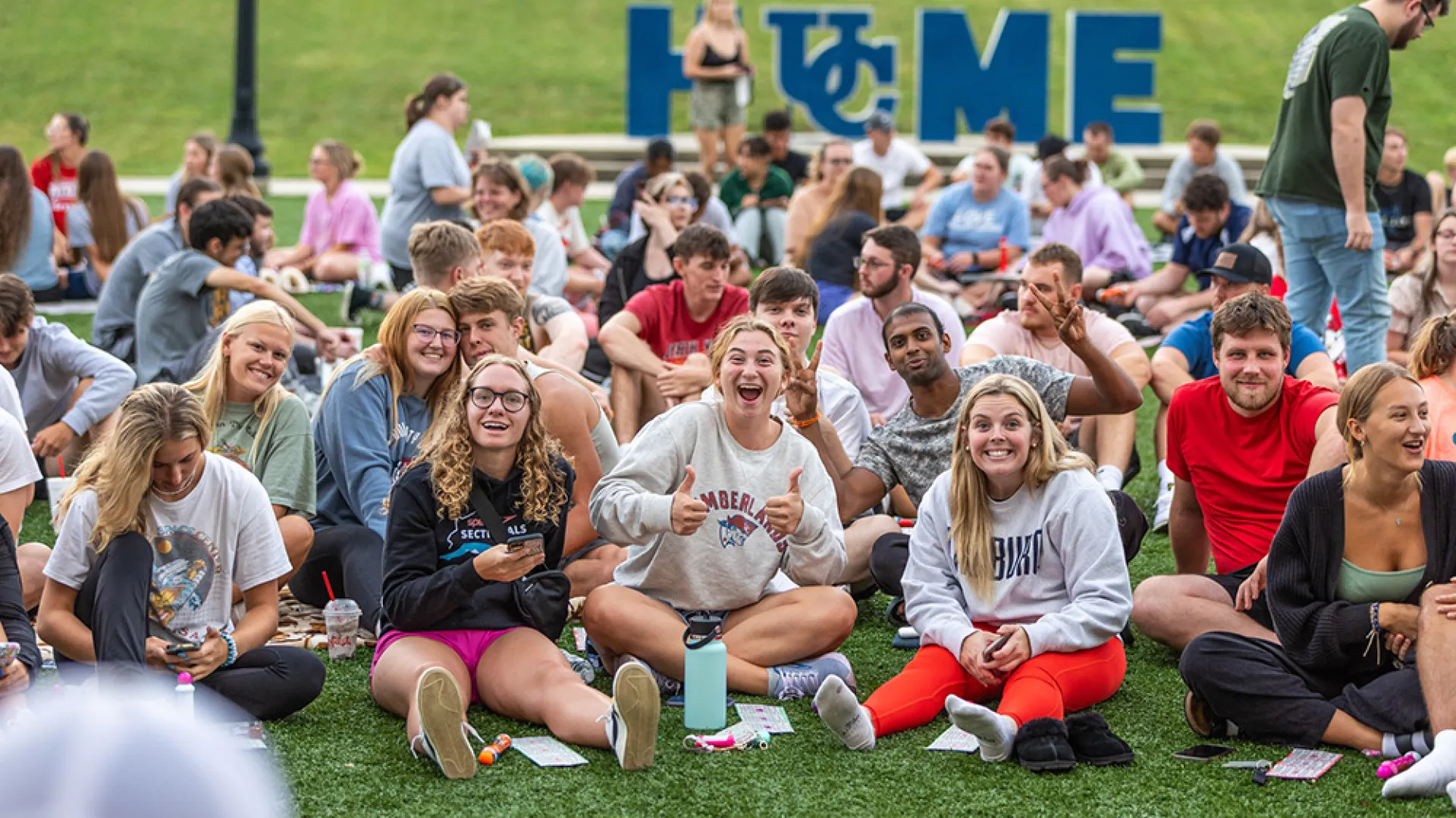 crowd of students sitting on lawn