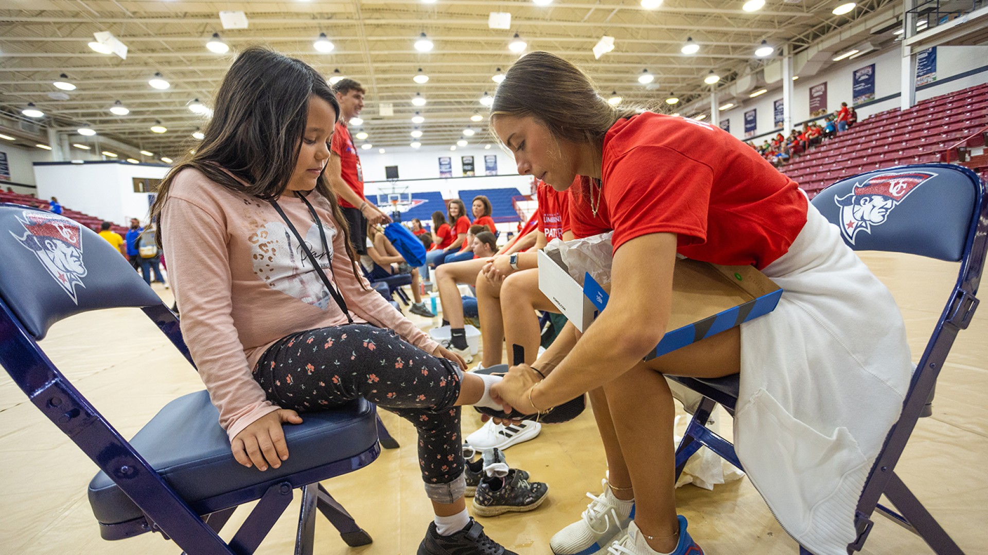 A Cumberlands student helps a local child try on new shoes