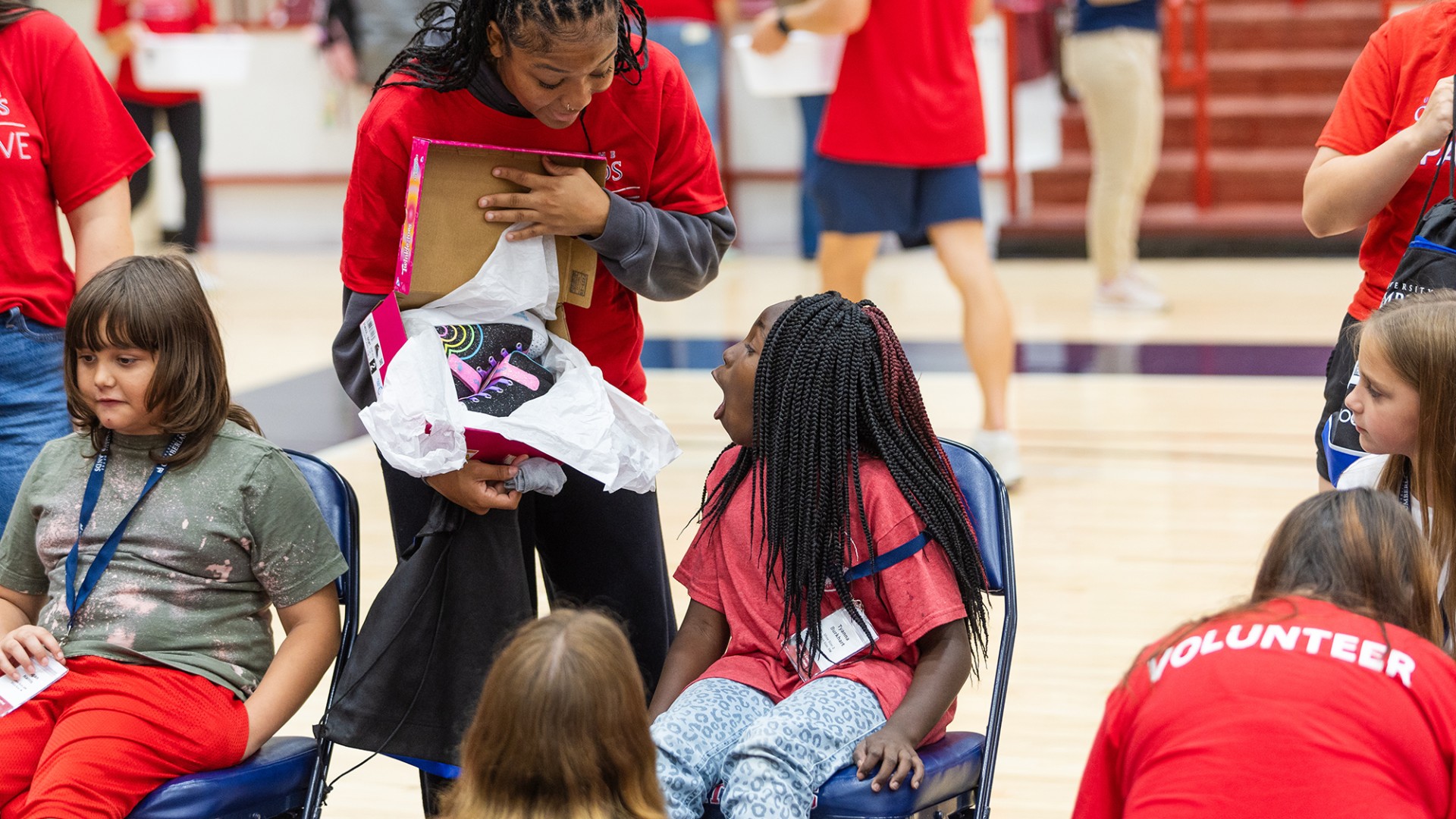 A female college volunteer shows a local female elementary student a new pair of shoes during Cumberlands annual service event. 