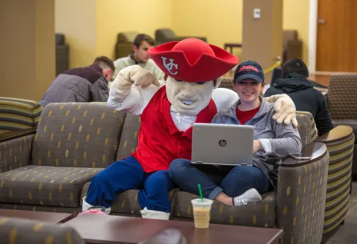 The university mascot posing with a student.