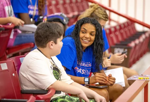 College student speaking with a child