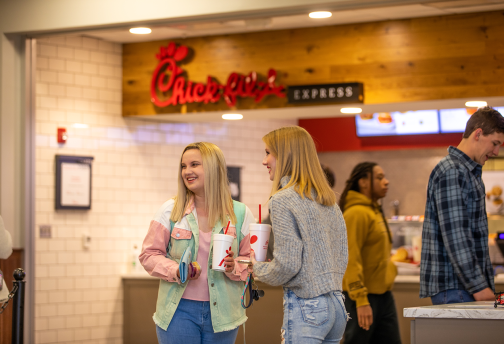 Students chat in line with each other in the campus grille. 