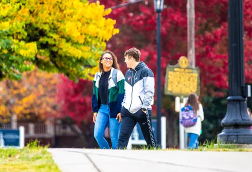 Two students walking to class during fall