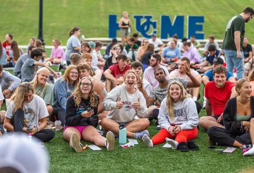 crowd of students sitting on lawn