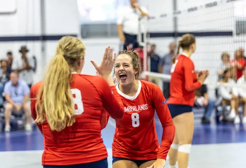 Volleyball players celebrate following a score 
