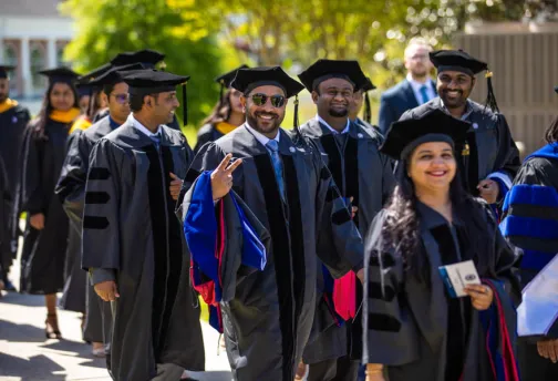Executive students walking toward graduation ceremony