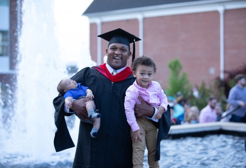 A graduate celebrating with his children