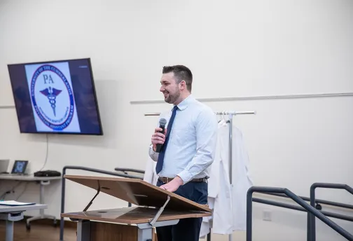 Medical student giving speech onstage. 