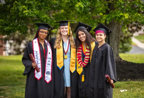 Four wrestlers pose after graduation