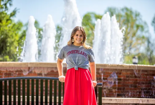 A Cumberlands student stands in front of the fountain on campus.