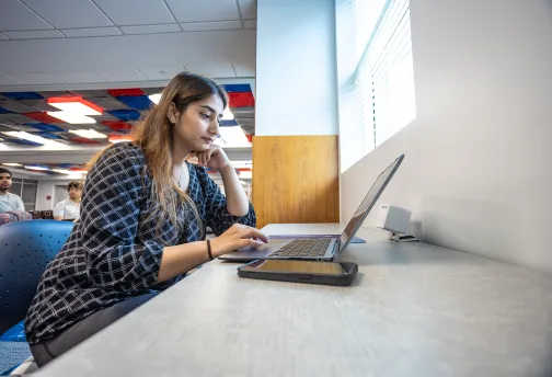 A graduate business student studies in the library. 