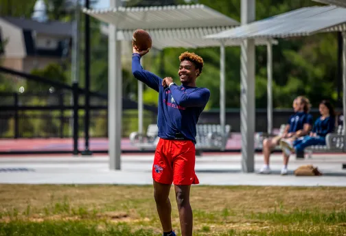 A student throws a football to another student.