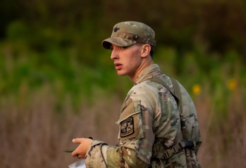 A male ROTC student navigates a scenario during a field exercise. 