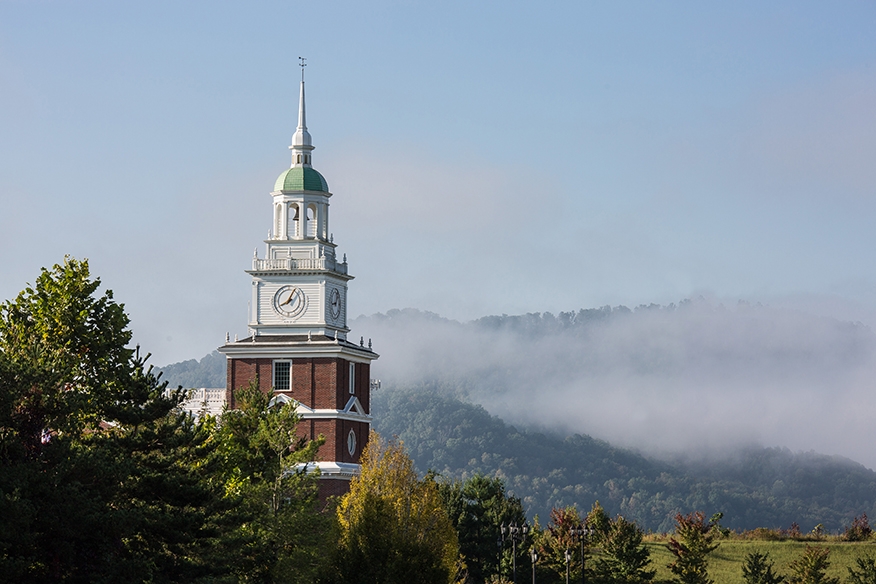 clock tower of business school and fog and mountains 