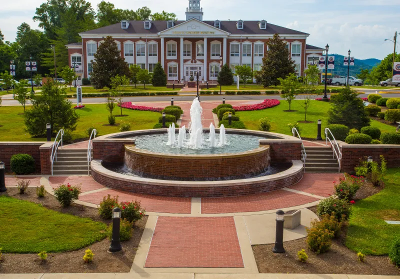 A water fountain in the middle of the college campus. 