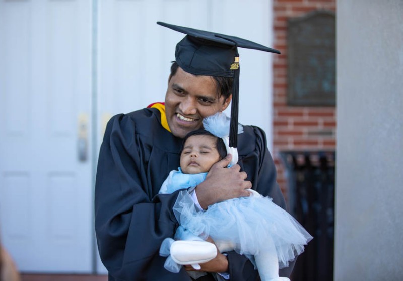 Executive graduate holding his baby girl