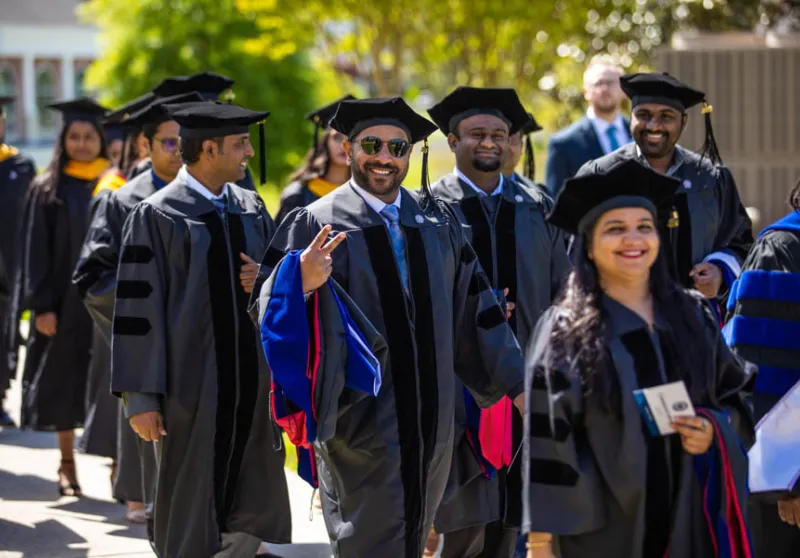 Executive students walking toward graduation ceremony