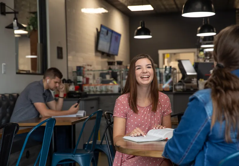 A Cumberlands student studies her Bible at a coffeeshop