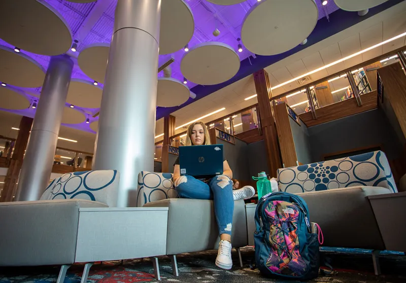 A student using a laptop inside renovated library