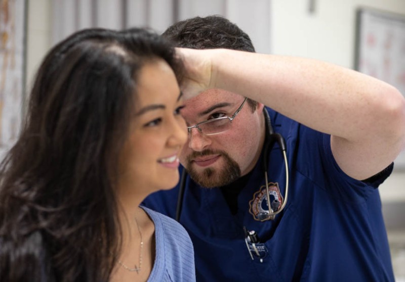 PA student looking inside a patient's ear