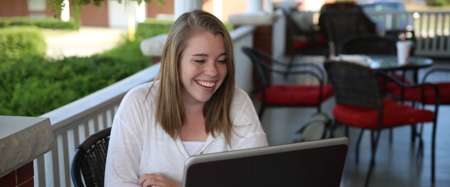 A student on a laptop outside