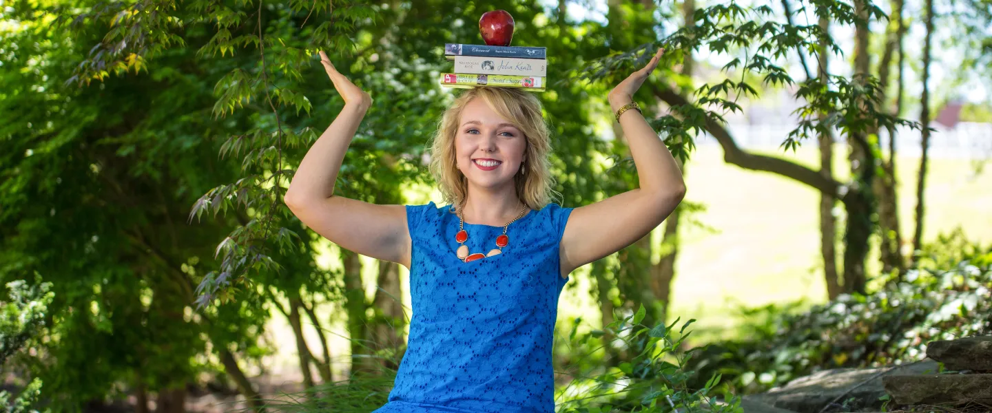 A student balancing books on her head