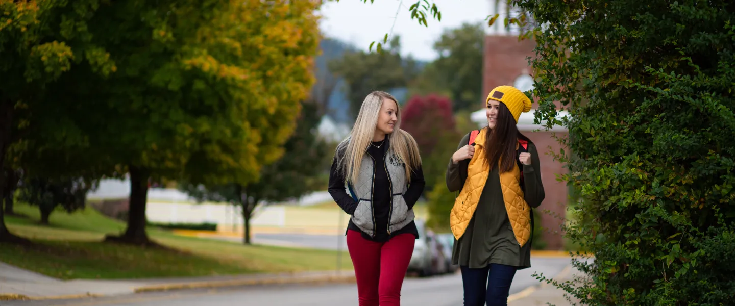 Two students on a sidewalk