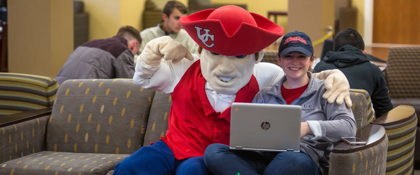 The university mascot posing with a student.