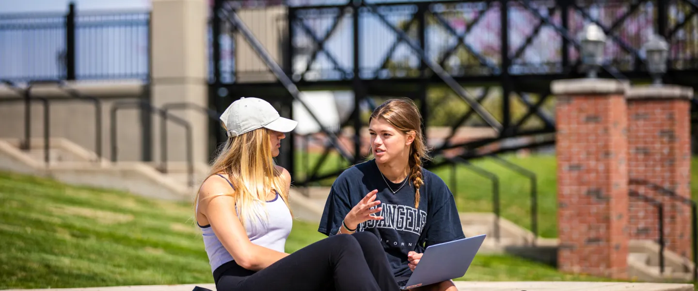Two students having a conversation outside