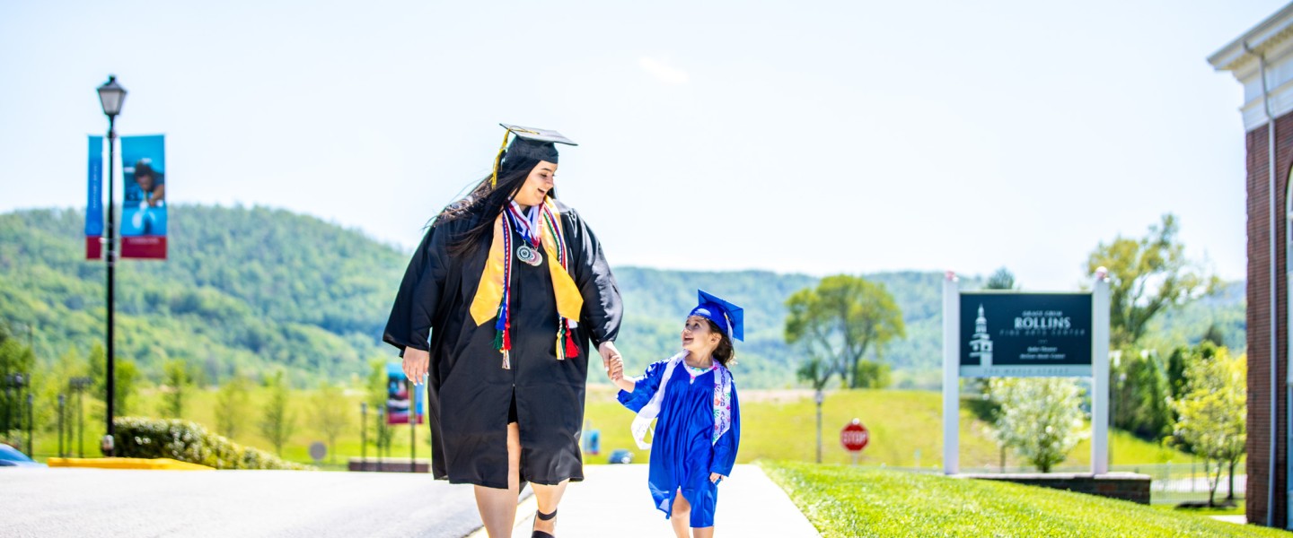 A woman and child both wearing cap and gown