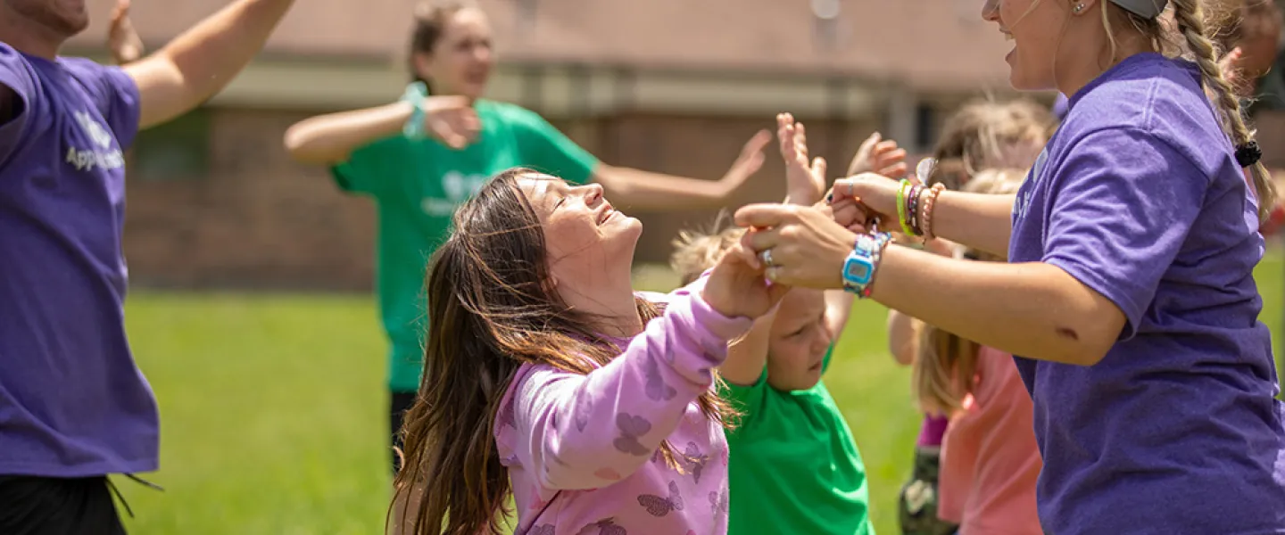 Students leading children in summer camp activities