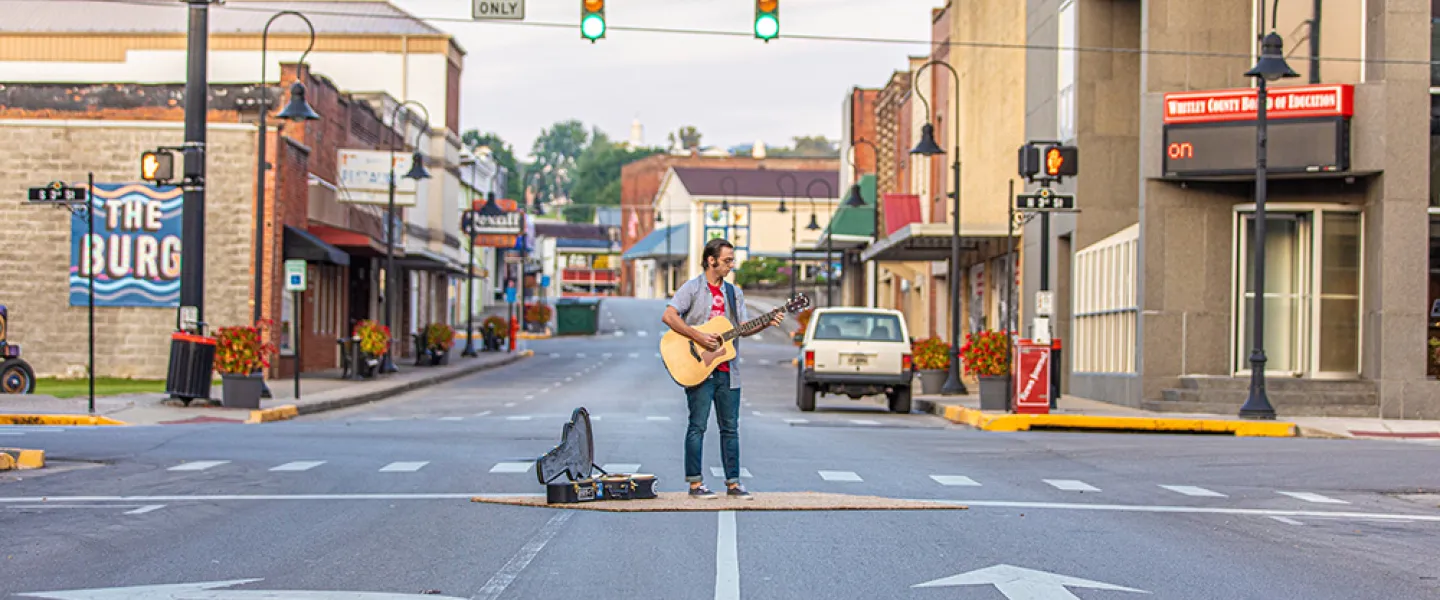 a man playing guitar in the street