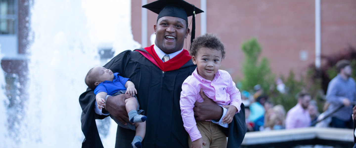A graduate celebrating with his children
