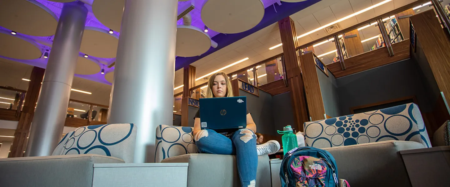 A student using a laptop inside renovated library