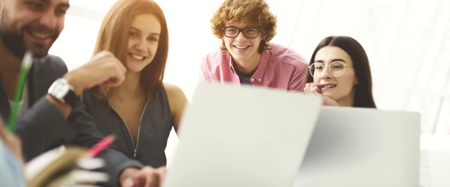 A group of people looking at a laptop