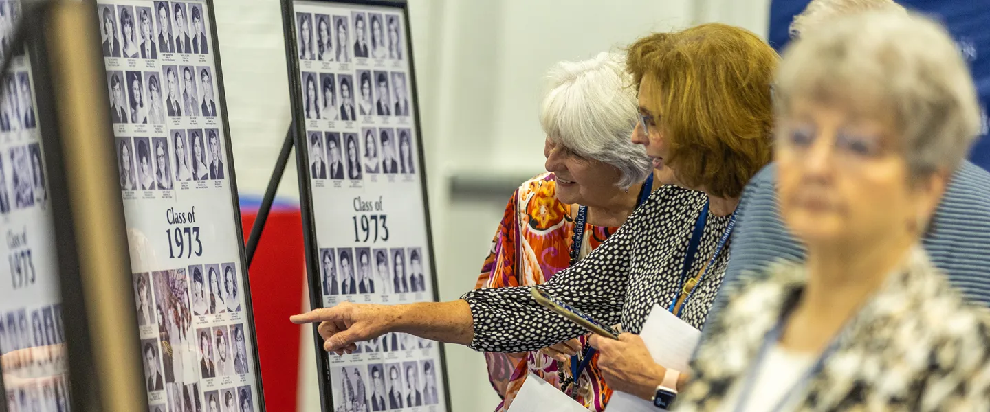 Alumni look at class photos during the 2023 Homecoming celebration