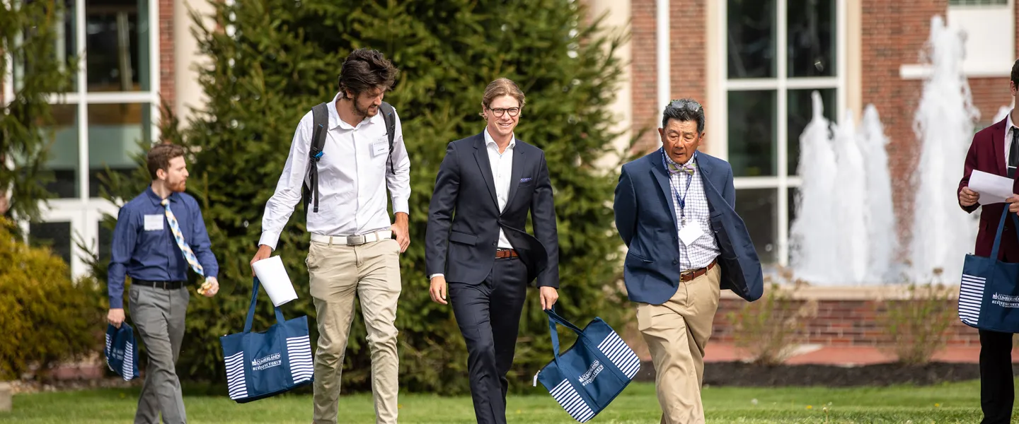 Students speak with a business professor following the annual forum. 