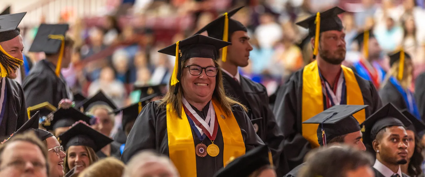 Students stand during commencement and are recognized for their academic accomplishments. 