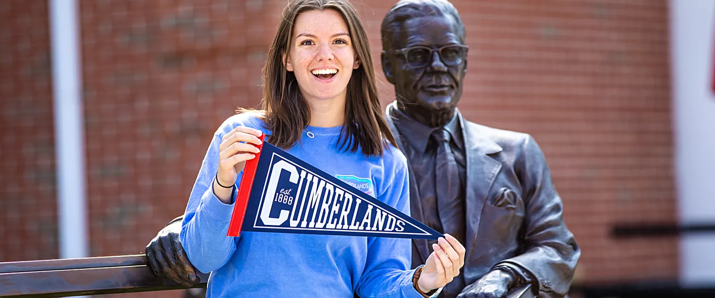 A Cumberlands alumna holds a pennant to display her school spirit. 