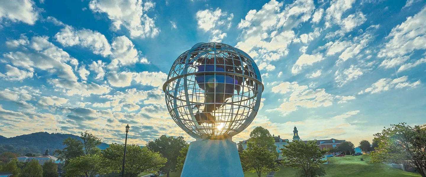 The sun rises behind the globe statue on Cumberlands' campus. 