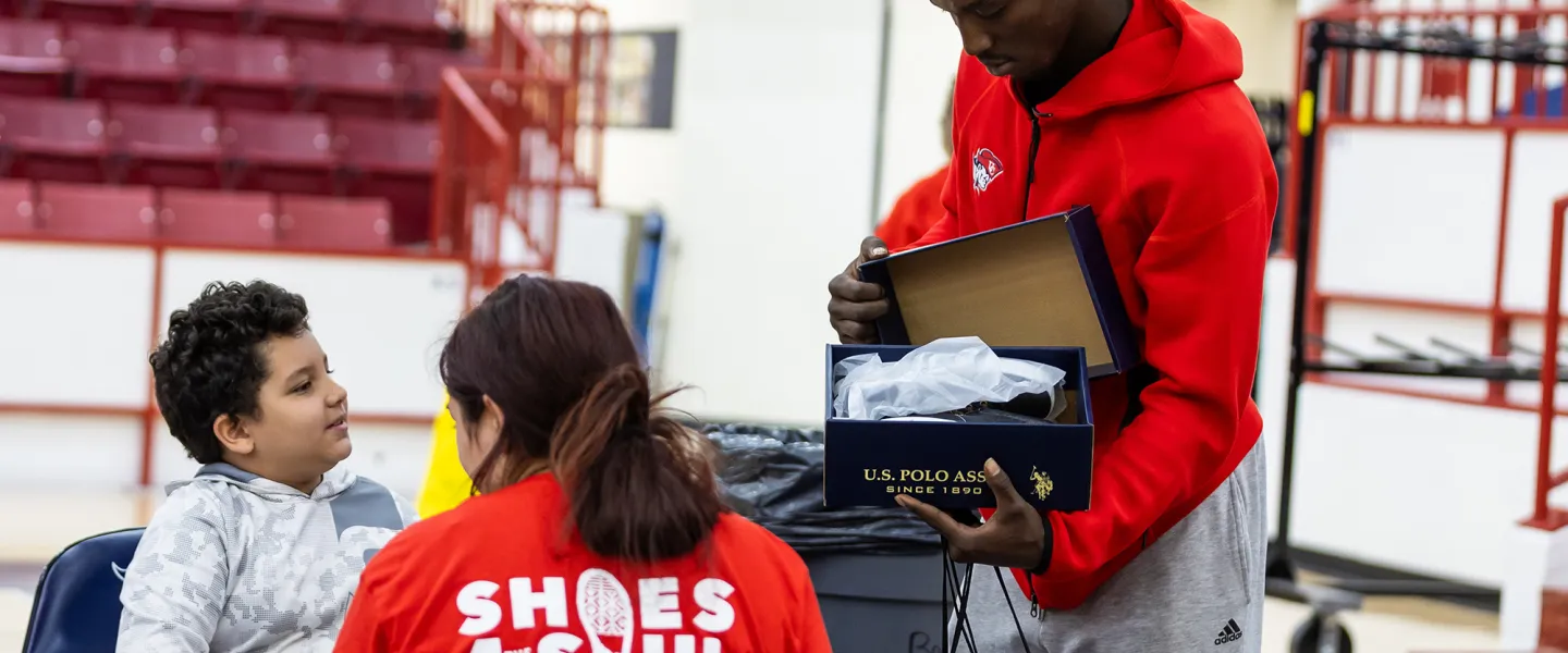 Cumberlands students show a student from a local school a pair of new shoes during Shoes 4 the Soul. 