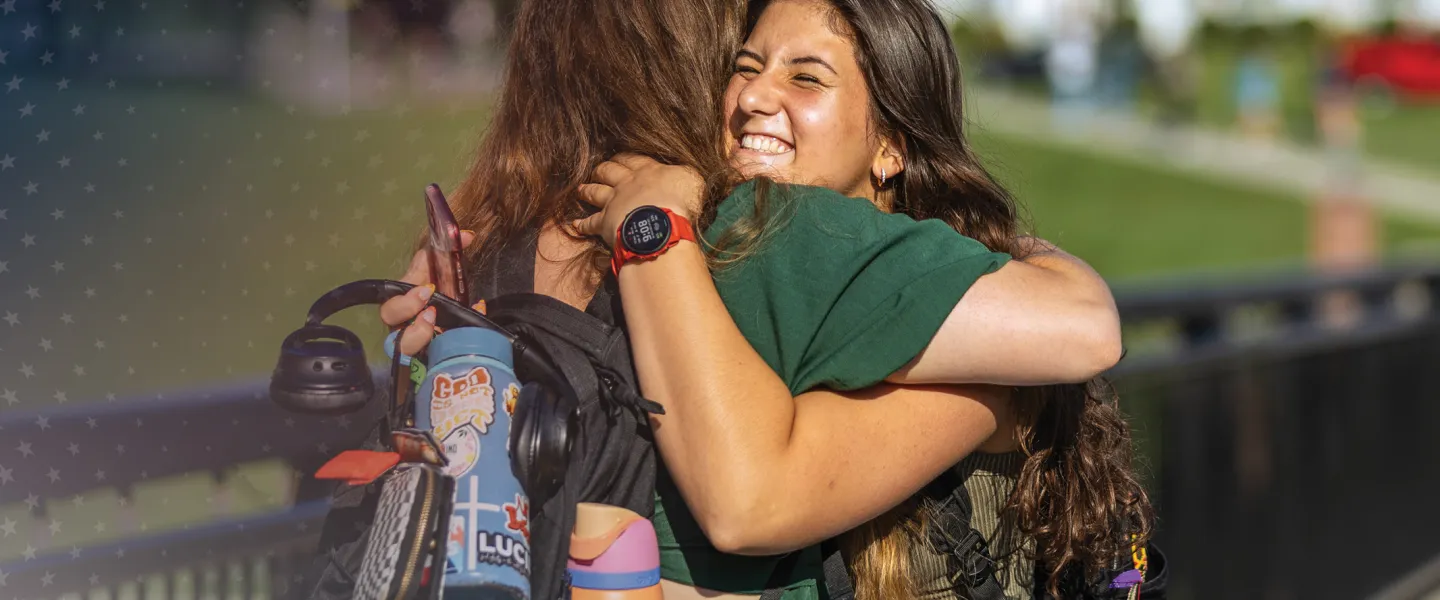 Students hug on their way to class. 