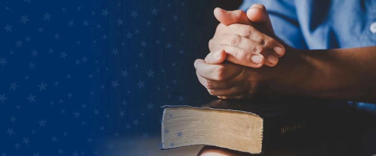 Clasped Hands Over Bible