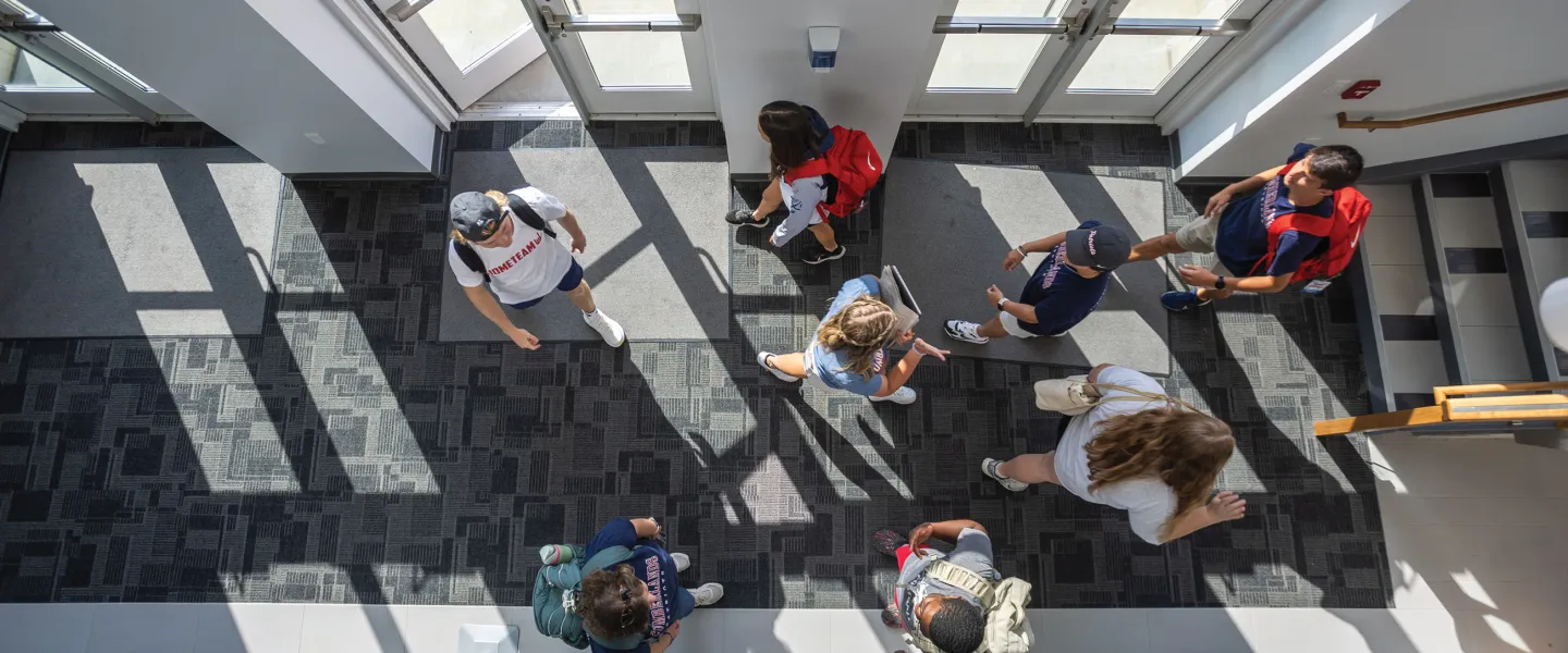 Students walk through the foyer of the library. 